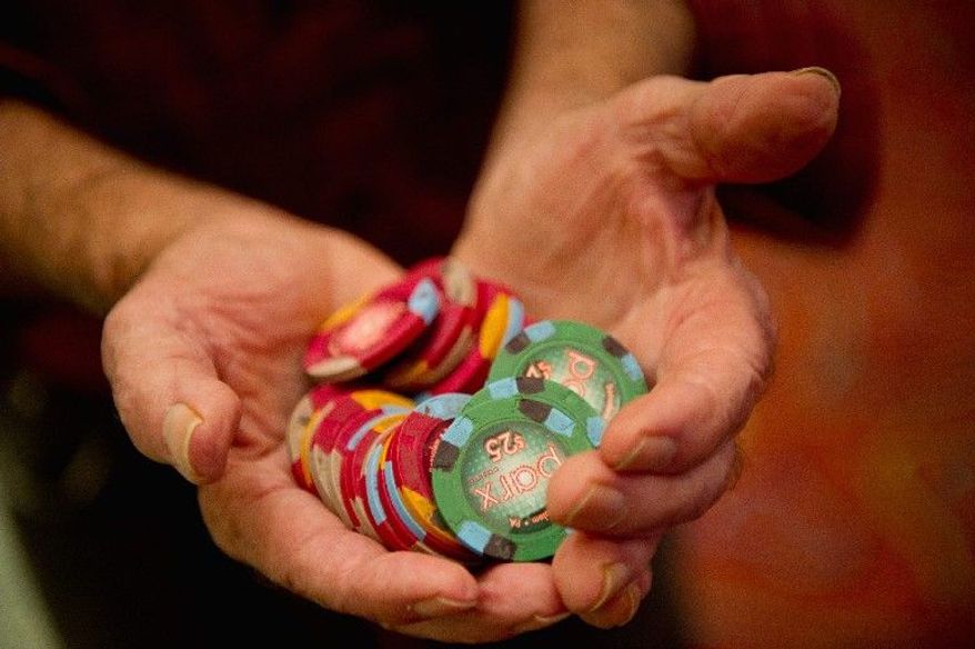 Bill Bregenzer of Flemington, N.J., shows off his winnings while standing in line for a cashier near the gambling floor last week in Parx Casino, near Philadelphia. (Andrew Harnik/The Washington Times)