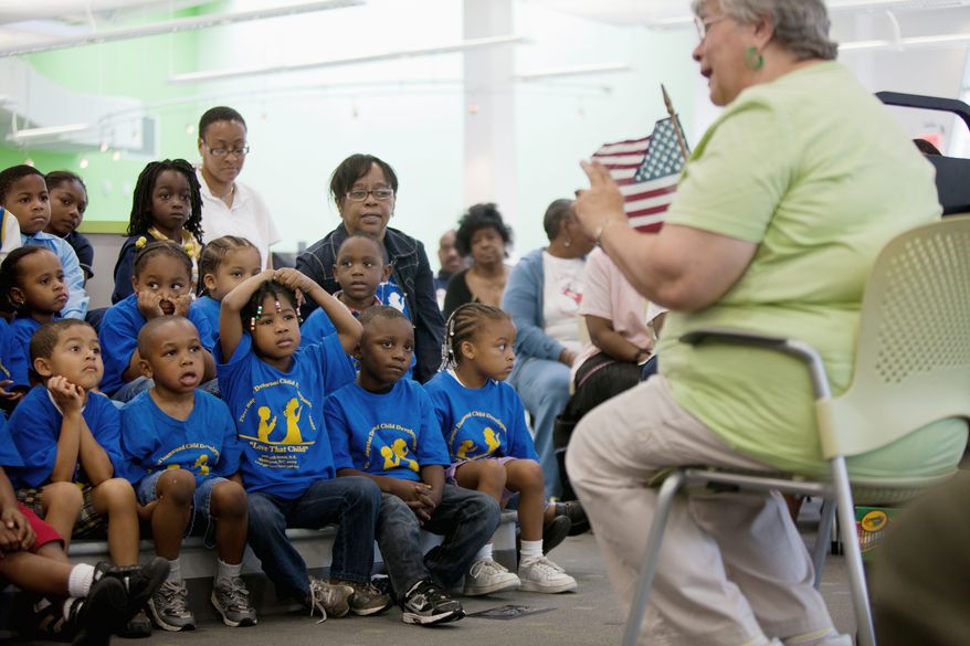 A librarian at the Deanwood Neighborhood Library in D.C., talks June 16, 2011, to a group of kindergarten students from nearby Houston Elementary School about the Pledge of Allegiance. (Pratik Shah/The Washington Times)