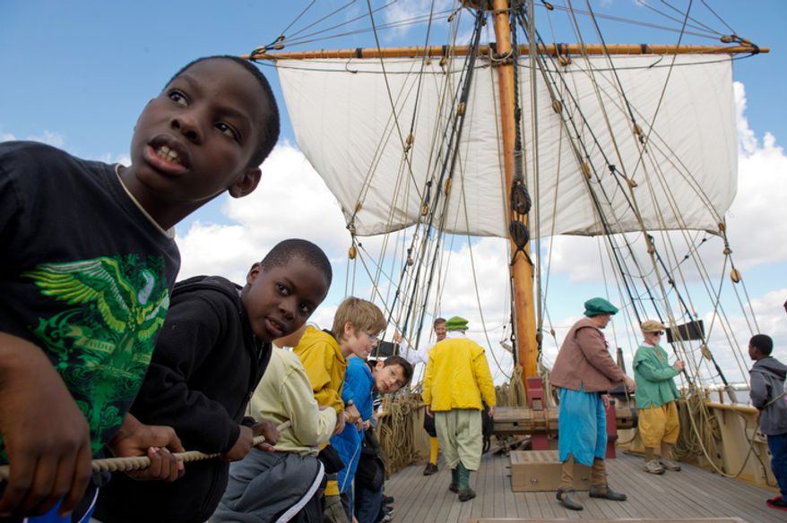 4th Graders Alhaji Conteh, left, and Alhaji Sesay, second from left, from James Polk Elementary School in Alexandria learn how to turn a sail with the help of their classmates aboard the Godspeed. (Andrew Harnik / The Washington Times)