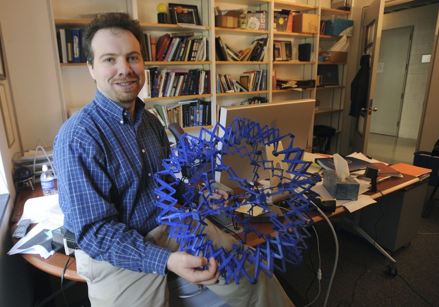 In this Sept. 19, 2008, handout photo provided by the John D. and Catherine T. MacArthur Foundation, astronomer Adam Riess sits in his office at Johns Hopkins University in Baltimore. The Royal Swedish Academy of Sciences says American Saul Perlmutter, U.S.-Australian citizen Brian Schmidt and U.S. scientist Adam Riess share the 2011 Nobel Prize in physics. (AP Photo/The John D. and Catherine T. MacArthur Foundation, Gail Burton