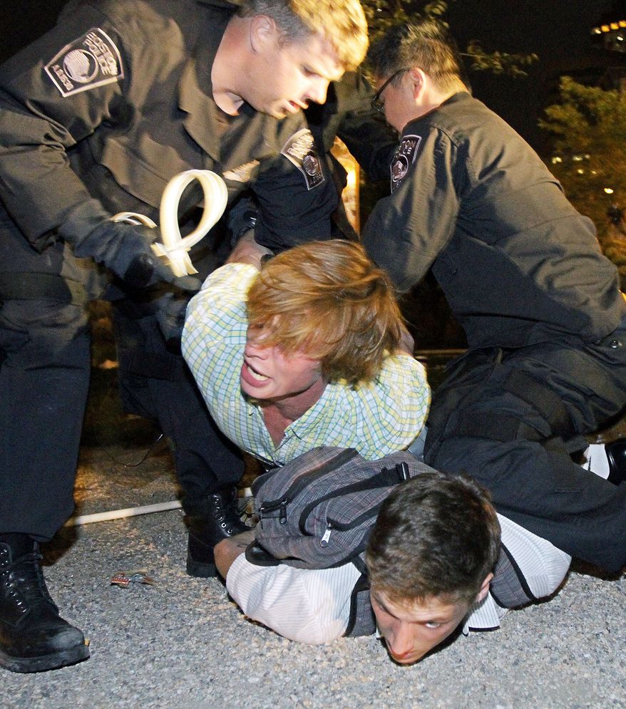 Boston Police officers arrest protesters on Tuesday in a section of the Rose Fitzgerald Kennedy Parkway adjacent to Dewey Square in Boston. (Boston Herald via Associated Press)
