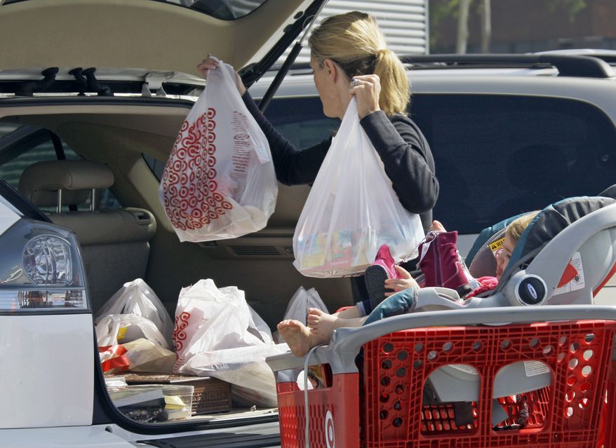 **FILE** A woman with a child loads purchases from a Target store into her car Sept. 29, 2011, in Culver City, Calif. (Associated Press)