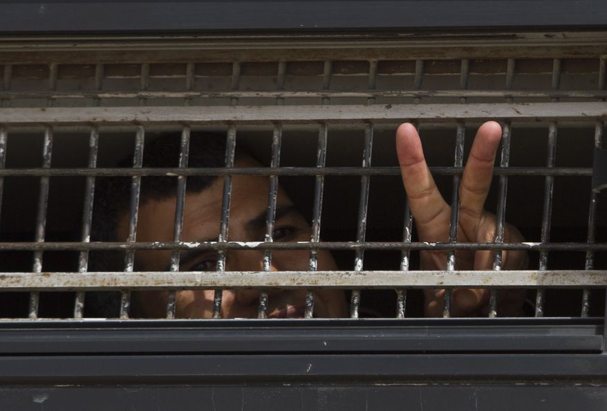 On Sunday, Oct. 16, 2011, a Palestinian prisoner flashes a V-sign on board an Israeli Prison Service bus transferring Palestinian prisoners who are to be exchanged for captured Israeli Sgt. Gilad Schalit. (AP Photo/Ariel Schalit)