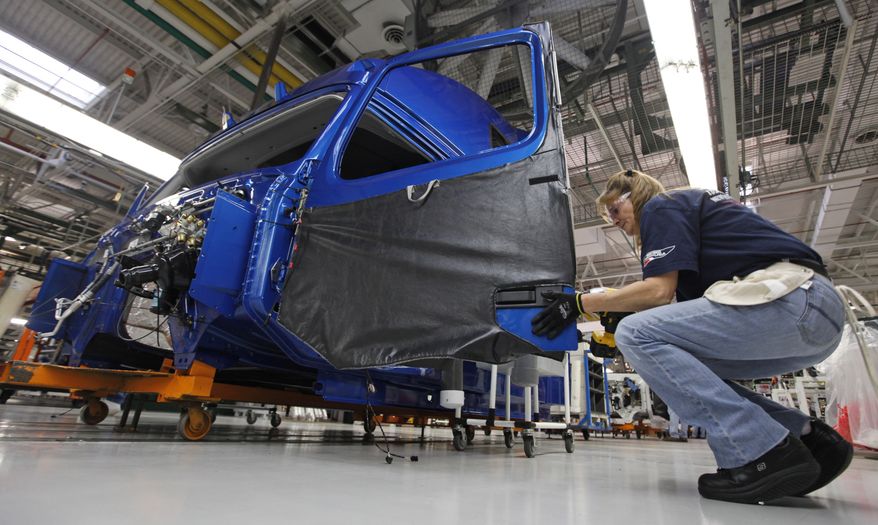 **FILE** Shelby Corvin installs a door handle on a truck cab on the Volvo truck assembly line at the Volvo plant in Dublin, Va., on Jan. 26, 2011. (Associated Press)