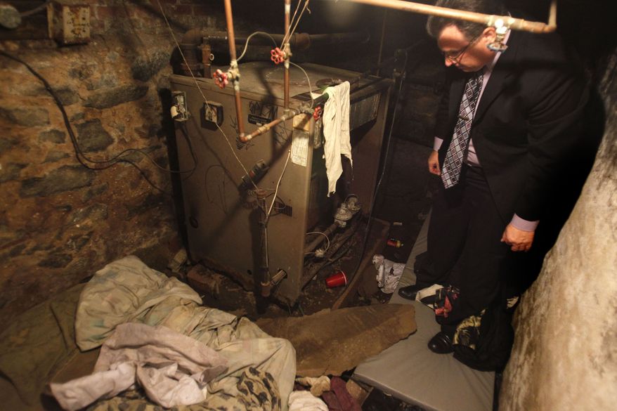 On Monday, Oct. 17, 2011, Philadelphia police Sgt. Joseph Green investigates the dank basement room where four weak and malnourished mentally disabled adults, one chained to the boiler, were found on Saturday. (AP Photo/Ron Cortes, Pool)