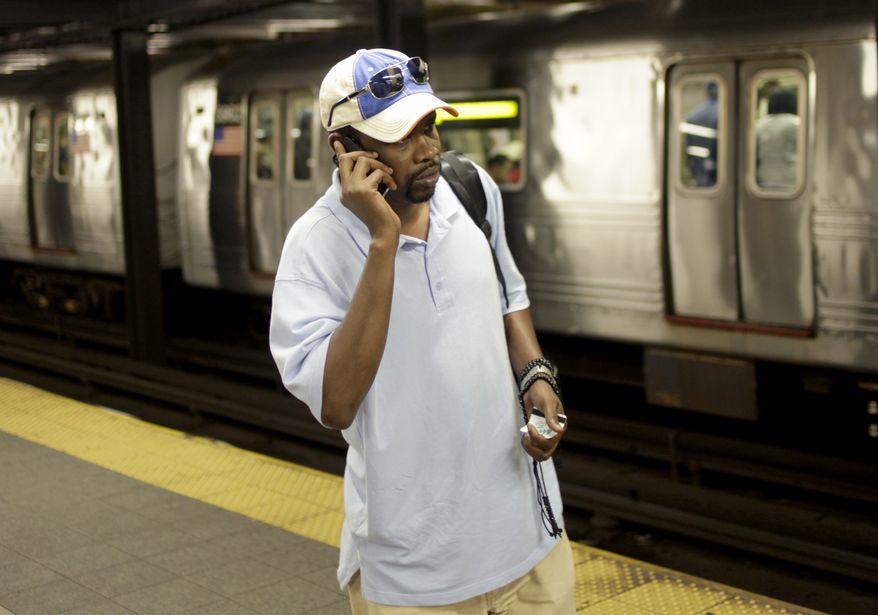 ** FILE ** In this Sept. 27, 2011, photo, Mory Bailo Aw makes a cellphone call from a subway platform to get some last-minute directions to a friends house in New York. (AP Photo/Seth Wenig, File)