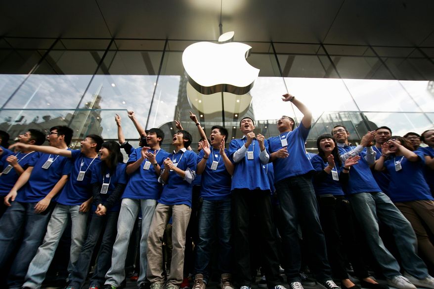 Employees cheer in front of the new Apple Store at its opening in September on a major commercial street in Shanghai, the third in the Chinese port city. Apple also has two stores in Beijing. (Associated Press)