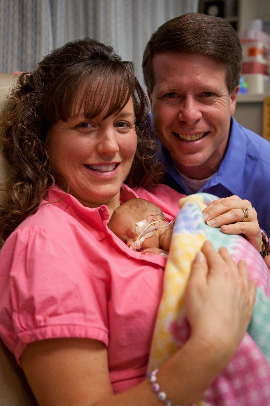 Jim Bob and Michelle Duggar hold their 19th child, Josie Brooklyn Duggar, who was born Dec. 11, 2009. A 20th child is on the way, the couple has announced. (TLC via Associated Press)