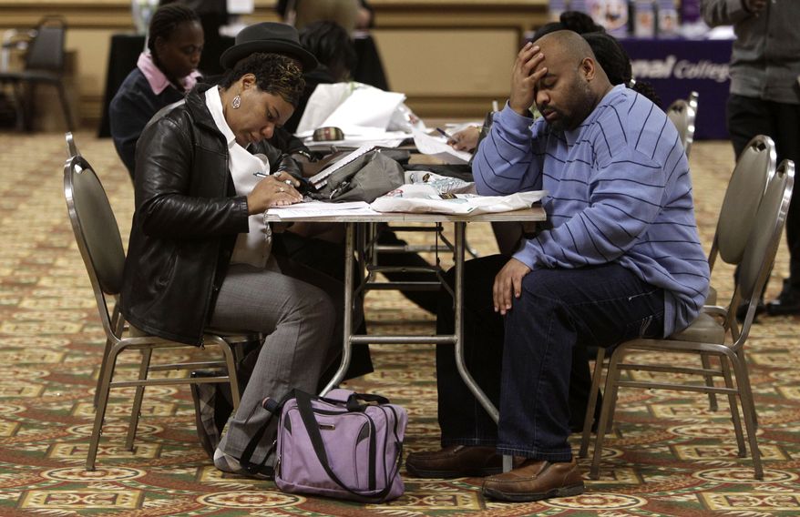 Tonya Crenshaw (left) and Kendrick Haraalson fill out applications at a job fair on Wednesday, Oct. 26, 2011, in Brookpark, Ohio. (AP Photo/Tony Dejak)