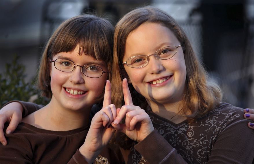 In a Monday, Nov. 7, 2011, photo, twin sisters Betsy, left, and Katie Overman pose for a photo in Madison, Wisc. The twins turned 11 on Nov. 11, 2011, or 11/11/11. (AP Photo/Wisconsin State Journal, Craig Schreiner)