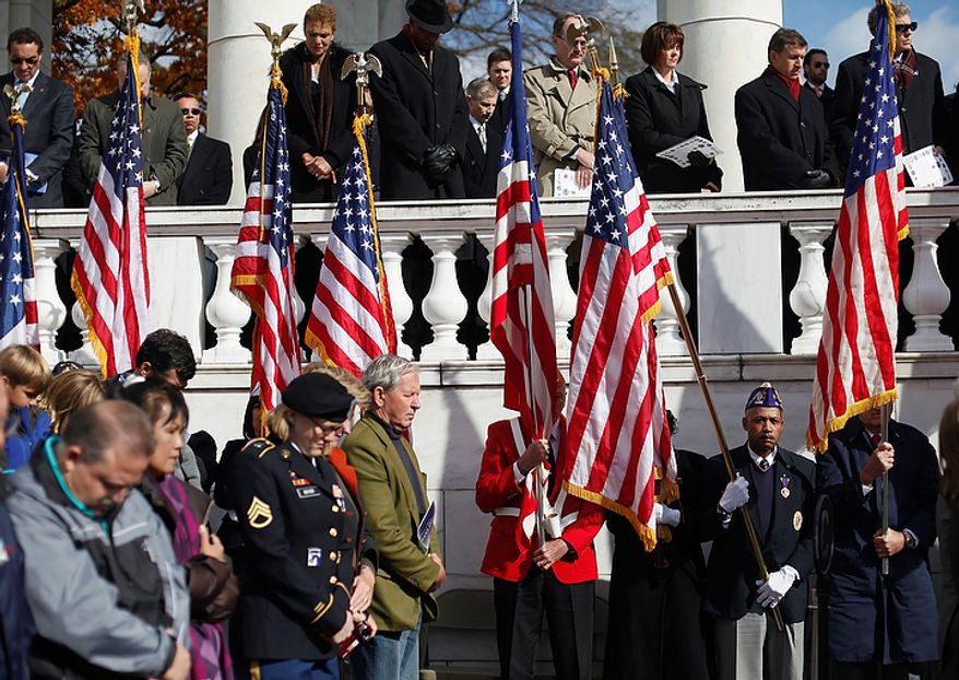 Guest bow their heads for a moment of silence during a Veteranís Day ceremony where President Barack Obama spoke, Friday, Nov. 11, 2011, at Arlington National Cemetery in Arlington, Va.(AP Photo/Pablo Martinez Monsivais)