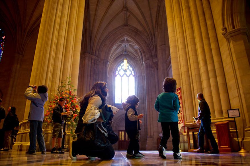 Dima Zalatimo of Georgetown checks out the National Cathedral with her two sons, 2 year old Milan, center, and 5 year old Luca, right, before the Service of Holy Eucharist begins. (Andrew Harnik / The Washington Times)