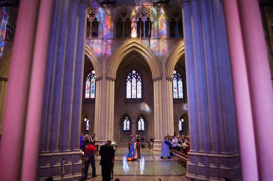 The Reverend Dr. Mariann Edgar Buddle, center, makes her way through the National Cathedral before she is consecrated as the ninth bishop of Washington at the service of Holy Eucharist. (Andrew Harnik / The Washington Times)
