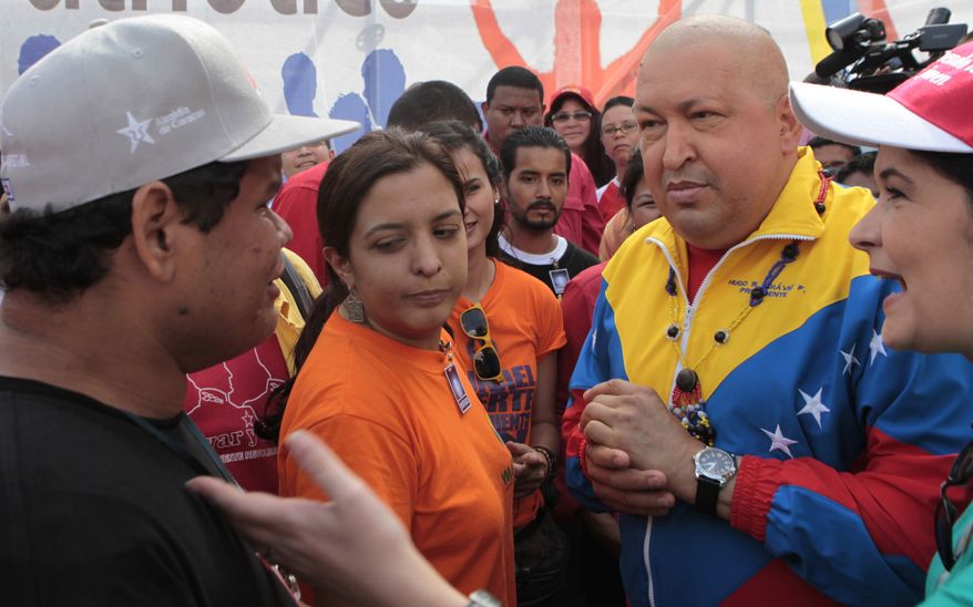 In this photo provided by Miraflores Presidential Press Office, Venezuelan President Hugo Chavez (second from right) speaks Nov. 13. 2011, to a supporter during a rally in Caracas, Venezuela. (Associated Press/Miraflores Presidential Office)