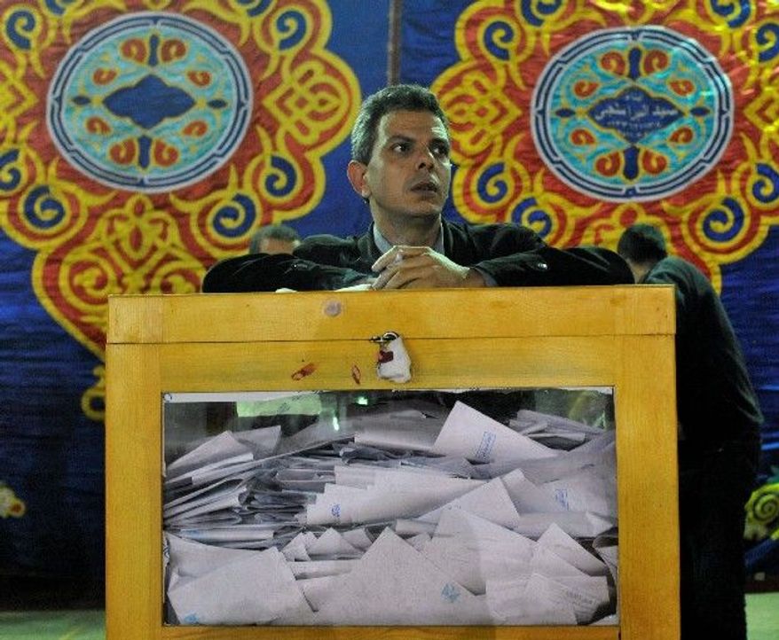 An Egyptian election official waits for the opening of ballot boxes at a vote-counting center in Cairo on Tuesday. "These elections are completely different from anything we've had before," said taxi driver Mohammed Farouk. (Associated Press)