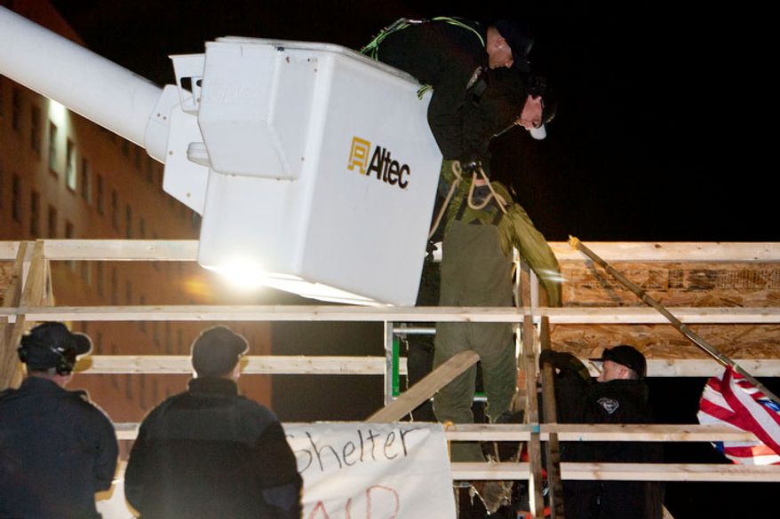 Park Police use a cherry picker to pull a protestor off the roof of a new structure the was erected in McPherson Square, in Washington, D.C. on Dec. 4, 2011.
(T.J. Kirkpatrick/ The Washington Times)