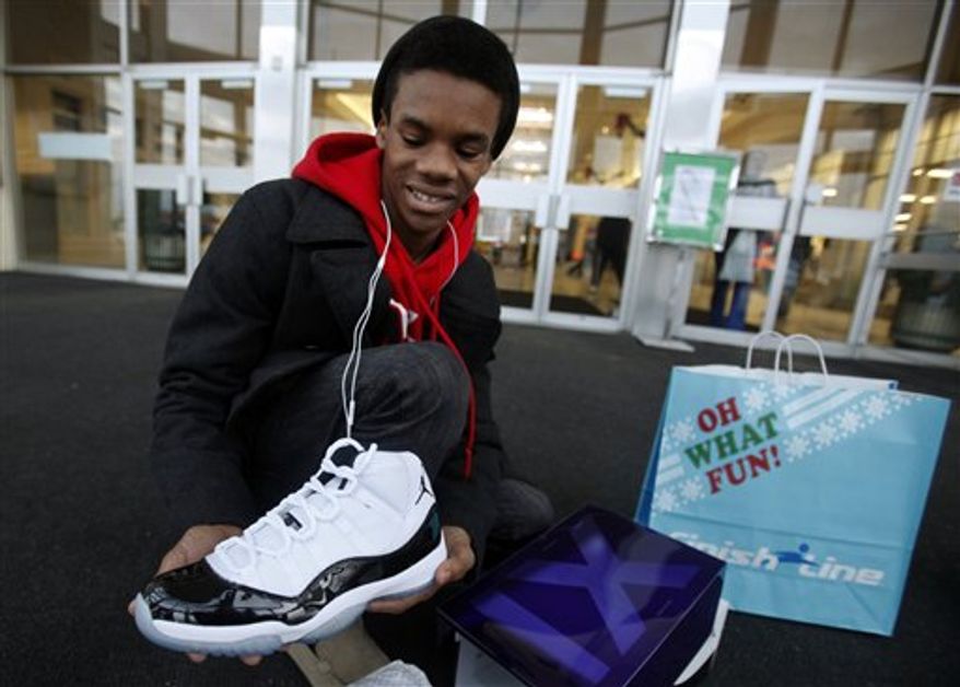 A young man shows off the Nike Air Jordan shoes he got for Christmas from his parents Friday, Dec. 23, 2011. (AP Photo/The Indianapolis Star, Danese Kenon)