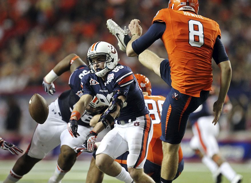 Auburn's Garrett Harper (86) blocks a punt by Virginia's Jimmy Howell (8) in the first quarter of the Chick-fil-A Bowl on Saturday, Dec. 31, 2011, in Atlanta. (AP Photo/Atlanta Journal & Constitution, Jason Getz)