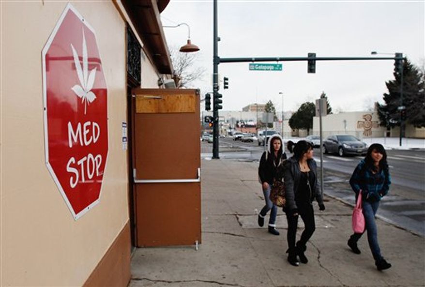**FILE** Three young girls walk past the Med Stop marijuana dispensary in Denver, located across from Del Pueblo Elementary School, on Jan. 12, 2012. (Associated Press)