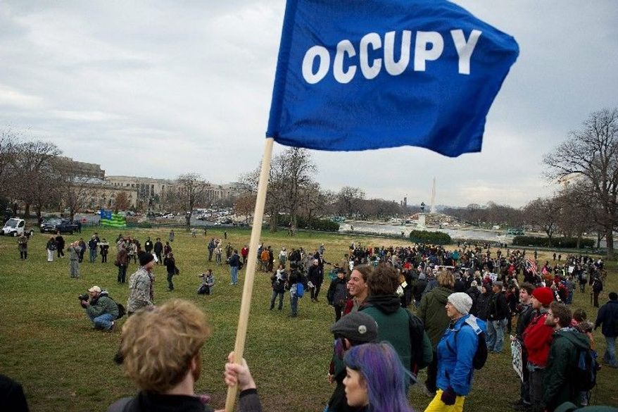 John Amick of the District with his Occupy flag gathers with Occupiers from McPherson Square and Freedom Plaza on the West Lawn. (Rod Lamkey Jr./The Washington Times)