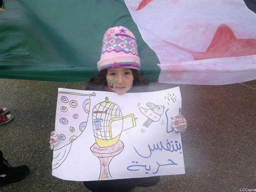 In this citizen journalism image provide by the Local Coordination Committees in Syria, a young Syrian girl holds an Arabic placard read:"I am breathing freedom," during a demostration against the Syrian regime, in Homs, Syria, on Tuesday Jan. 24, 2012. With Arab pressure mounting to end 10 months of bloodshed, the Syrian regime vowed Tuesday to solve its own problems even if "half the universe" is conspiring against it. (AP Photo/Local Coordination Committees in Syria)