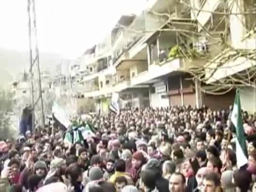 This image from amateur video made available by the Ugarit News group and shot on Jan. 29, 2012, purports to show a funeral in Damascus, Syria. The Syrian military launched an offensive to regain control of suburbs on the eastern edge of Damascus, storming neighborhoods and clashing with groups of army defectors in fierce fighting that sent residents fleeing and killed at several people, activists said. (Associated Press/Ugarit News Group via APTN)