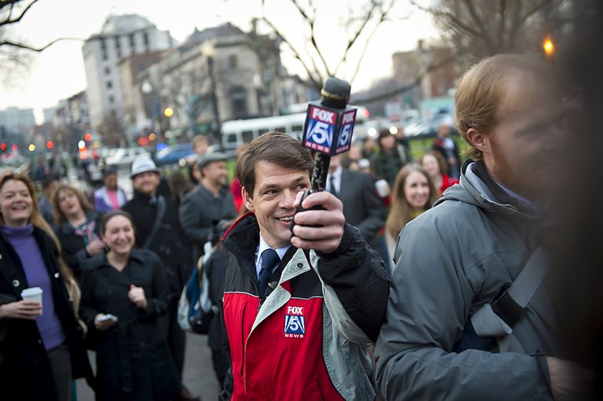 Fox 5 meteorologist Tucker Barnes holds up his microphone to get the groundhog's prediction during the inaugural Groundhog Day event at Dupont Circle in Washington on Thursday, Feb. 2, 2012. (Rod Lamkey Jr./The Washington Times)