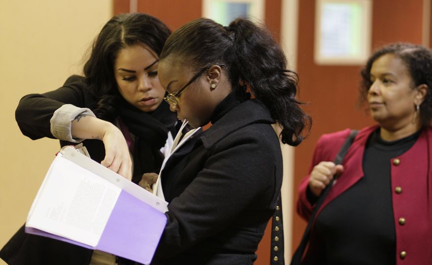 Job seekers Cameo Taylor (left) and Angelique McGuire (center), both of San Francisco, wait in line to register at a career fair event in San Francisco on Saturday, Jan. 28, 2012. (AP Photo/Eric Risberg)