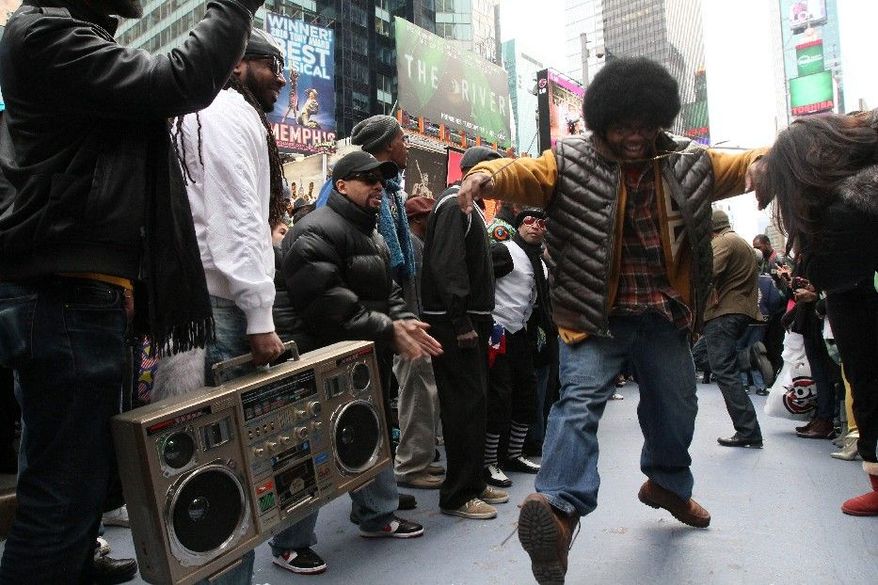 Participants of a "Soul Train" flash mob make their way along the dance line during a tribute to show creator Don Cornelius Saturday Feb. 4, 2012 in New York's Times Square. (AP Photo/Tina Fineberg)