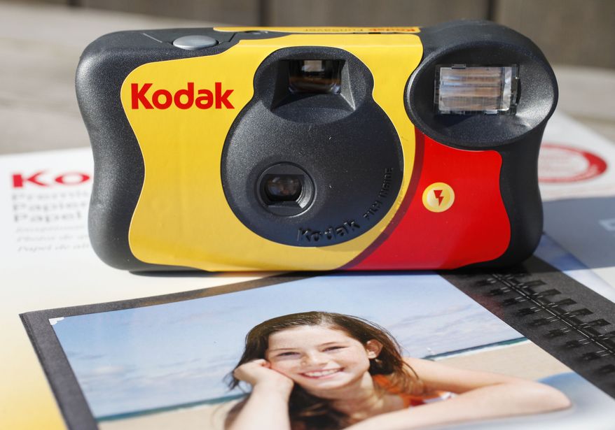 A Kodak FunSaver single-use camera sits on a box of Kodak inkjet paper. (AP Photo/Mark Lennihan)