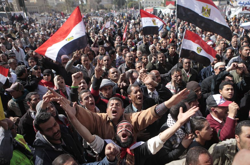 Egyptian protesters wave national flags and chant anti-Supreme Council of Armed Forces slogans during a protest Feb. 10, 2012, after prayers in Cairo's Tahrir Square, the focal point of Egyptian uprising. (Associated Press)