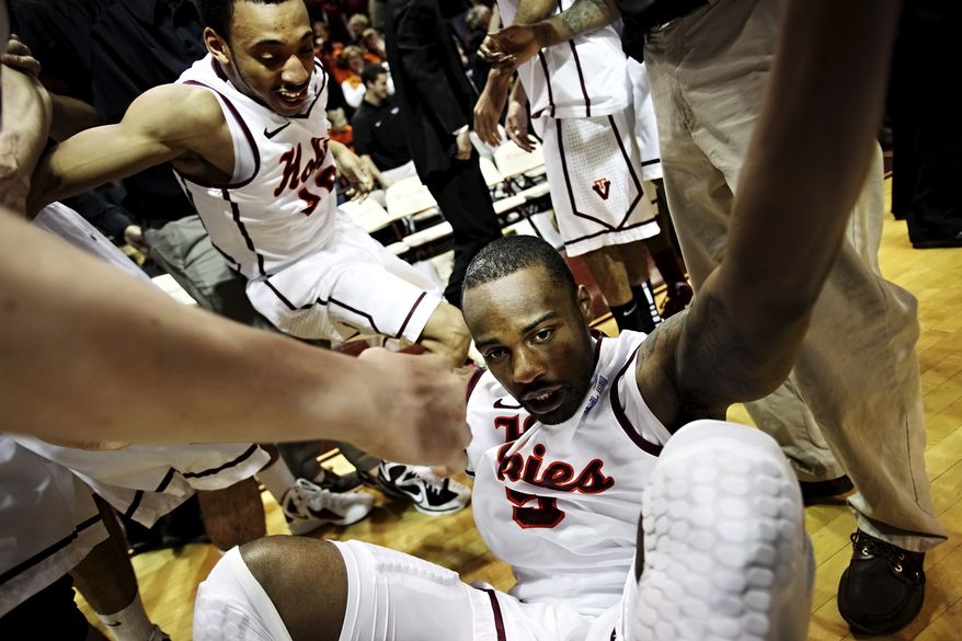 Teammates swarm Virginia Tech's Dorenzo Hudson after he hit the game-winning 3-pointer as time expired in overtime against Georgia Tech, Saturday, Feb. 18, 2012, in Blacksburg, Va. Virginia Tech won 74-73. (AP Photo/The Roanoke Times, Kyle Green)