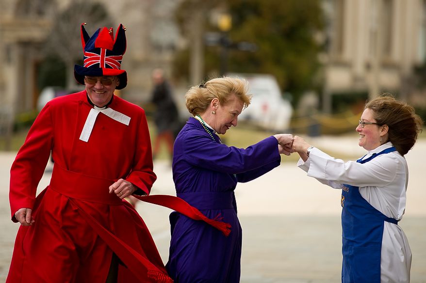 The Rev. Canon Ralph Godsall, priest vicar of Westminster
Abbey and visiting clergy at the Cathedral gets ready to start his race along side the Rev. Canon Jan Naylor Cope, National Cathedral Vicar who fist bumps with the Rev. Deborah Meister, Rector of St. Alban's Parish during the Washington National Cathedral Pancake Races held in front of the Cathedral on Shrove Tuesday, more commonly known as "Mardi Gras.", Washington, D.C., Tuesday, Feb. 21, 2012. This years annual Pancake Races are entitled the “Shake, Rattle & Race Edition,†in light of the earthquake damage the cathedral sustained earlier this year. (Andrew Harnik/The Washington Times)