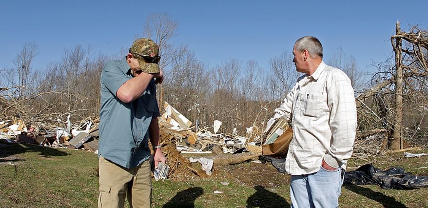Fred Beaty, left, wipes away tears as his brother Gary Beaty looks at the home near Crossville, Tenn. where a deadly tornado on Wednesday killed their sister-in-law, Melissa Evans and sent their brother Ricky Beaty to the hospital, Thursday, March 1, 2012. National Weather Service survey teams were set Thursday to evaluate damage from powerful storms that swept across the state, killing three people and damaging dozens of homes. (AP Photo/Wade Payne)