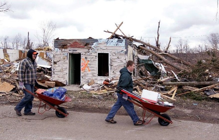 Volunteers look for residents in need of assistance Sunday as they attempt to recover possessions from their homes in Henryville, Ind., destroyed by Friday's tornadoes. With routines and communication disrupted, people have gone back to basics to learn about their loved ones and start rebuilding their lives. At St. Francis Xavier Catholic Church (top), pews during Mass were filled not only with people but also with donated clothing and supplies. (Associated Press)