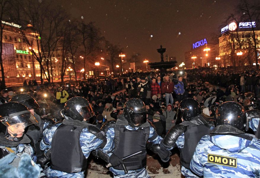 Police officers block opposition demonstrators after a massive rally in Pushkin Square in downtown Moscow on Monday, March 5, 2012, to protest Sunday's presidential election. (AP Photo/Sergey Ponomarev)