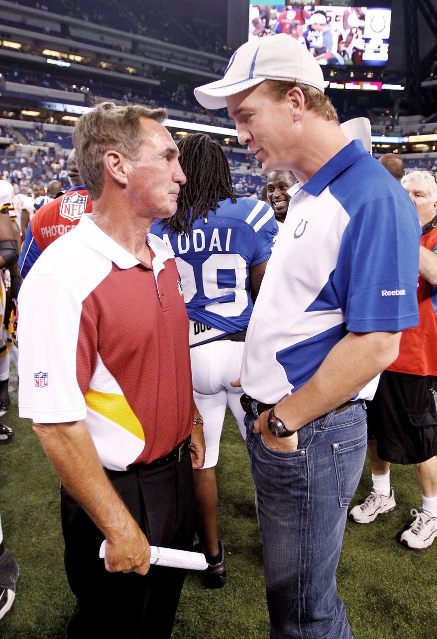 Mike Shanahan, head coach of the Washington Redskins, takes advantage of a chance to talk with Indianapolis Colts quarterback Peyton Manning after an NFL preseason football game in Indianapolis in 2011. (Associated Press)