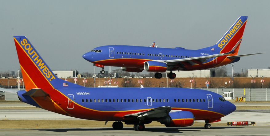 **FILE** A Southwest Airlines Boeing 737 waits to take off Feb. 9, 2012, at Chicago's Midway Airport as another lands. (Associated Press)