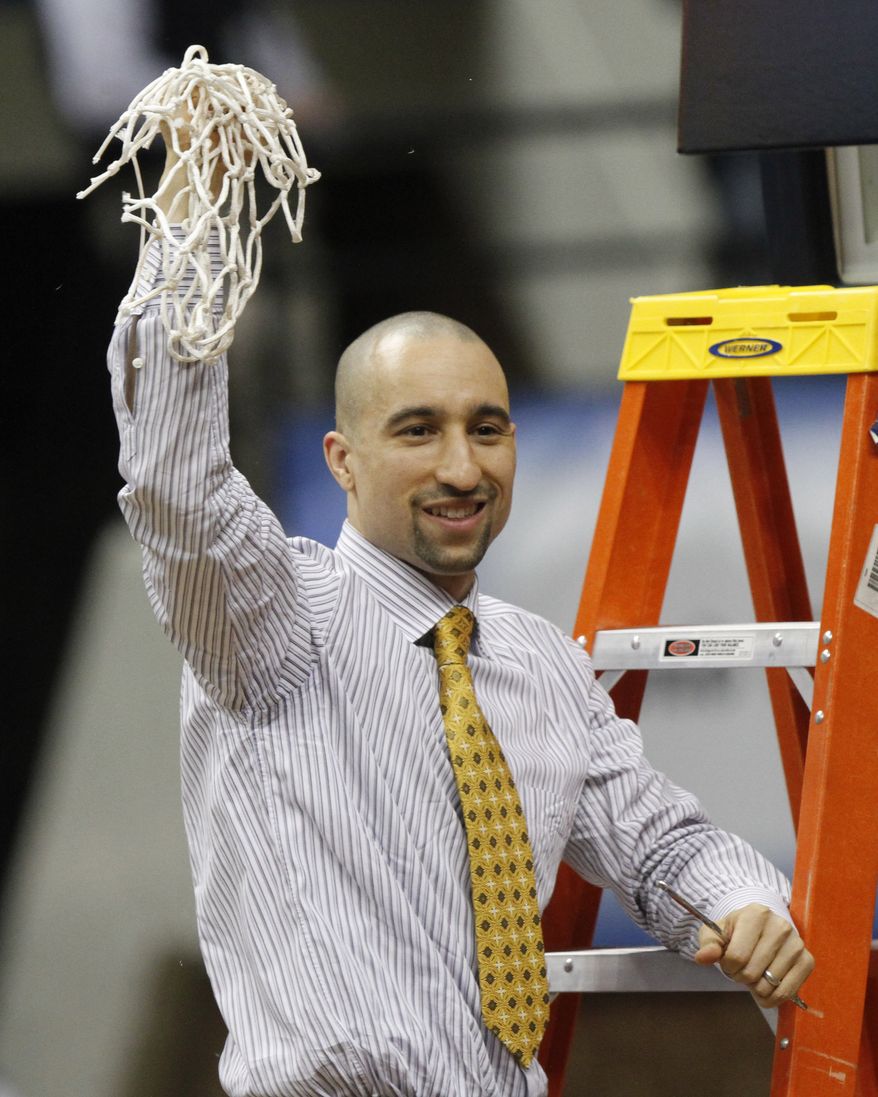 Virginia Commonwealth head basketball coach Shaka Smart waves the net after winning the Colonial Athletic Association Championship at the Coliseum in Richmond, Va., Monday, March 5, 2012. VCU beat Drexel 59-56. (AP Photo/Steve Helber)