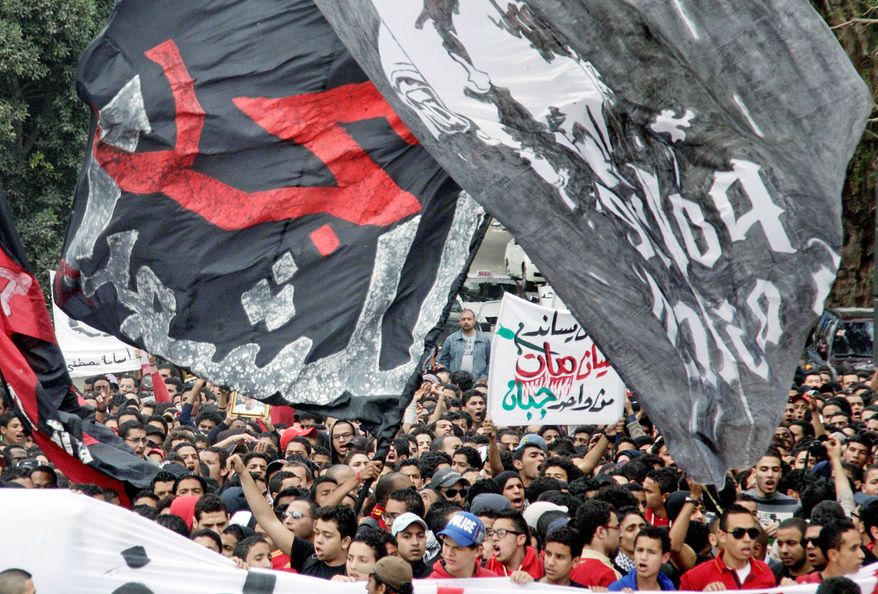 Thousands of Egyptian activists and soccer fans on Thursday participate in a march from the headquarters of the al-Ahly club toward the Egyptian general prosecutor's office in downtown Cairo to protest against what they say is the slow pace of procedures taken by the government to find and hold accountable those responsible for soccer violence in Port Said that claimed scores of victims. Arabic on the banner reads, "The glory for martyrs." (Associated Press)