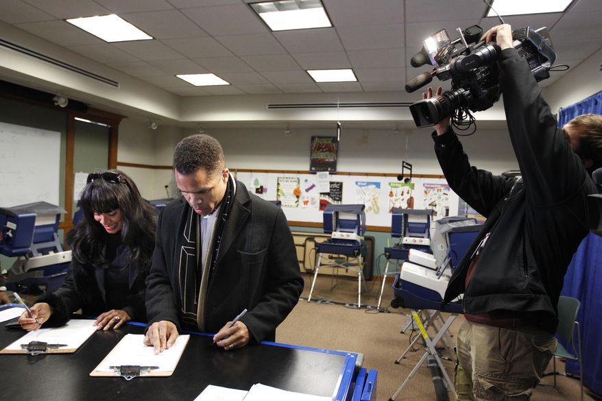Rep. Jesse L. Jackson Jr. and his wife, Chicago Alderman Sandi Jackson, take advantage of early voting at a polling station in Chicago on Friday, March 9, 2012. (AP Photo/M. Spencer Green)