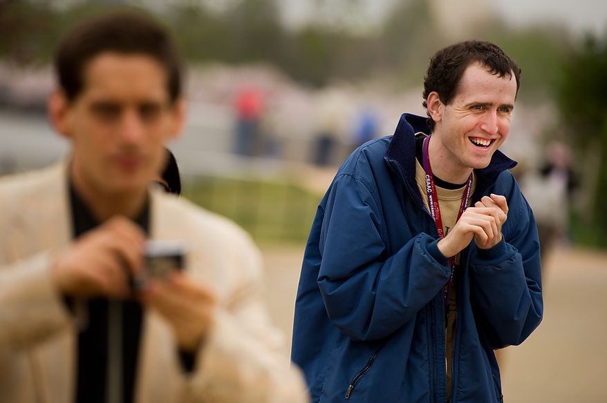 Brian D., right, smiles as he and James L., left, walk around with their cameras near the Jefferson Memorial as they and other autistic adults with Community Services for Autistic Adults and Children, based in Montgomery Village, Md., take photographs of the Cherry Blossoms along the Tidal Basin, Washington, D.C., Wednesday, March 21, 2012. The “InFocus Project†is a way for adults with autism to develop forms of self expression and social skills while producing work that has been featured in art shows, given to donors to C.S.A.A.C., and sold on an online store. (Andrew Harnik/The Washington Times)