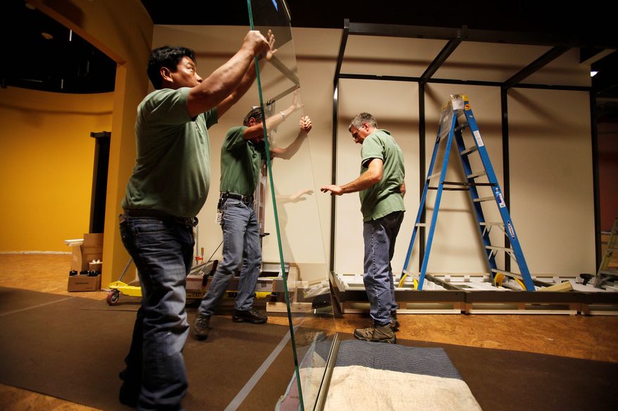** FILE ** In this Feb. 13, 2012, photo, Teng Phung, left, Chris Lugt, center, and Jim Slingo lift a glass panel destined for a display window in the new Museum of the Confederacy in Richmond, Va. (AP Photo/Richmond Times-Dispatch, Dean Hoffmeyer)