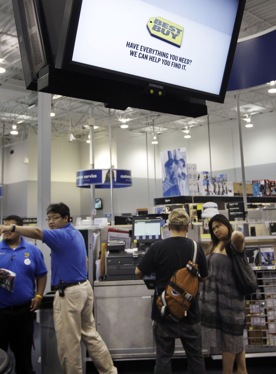 **FILE** Employees help out customers Sept. 12, 2011, at a Best Buy store in Mountain View, Calif. (Associated Press)