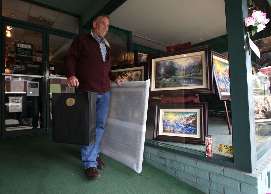 Tom Cuquet leaves the Thomas Kindade Gallery after purchasing several of the artist's works in Kinkade's boyhood hometown of Placerville, Calif., Monday, April 9, 2012. (AP Photo/Rich Pedroncelli)