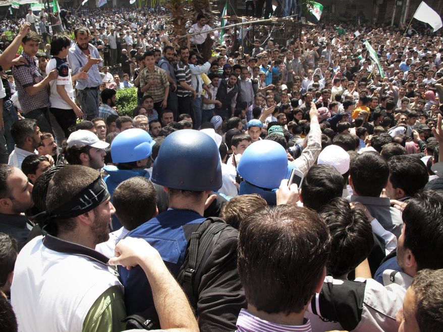 Syrian protesters gather around U.N. observers during their visit to the restive suburb of Douma, outside Damascus, Syria, on Monday, April 23, 2012. (AP Photo)