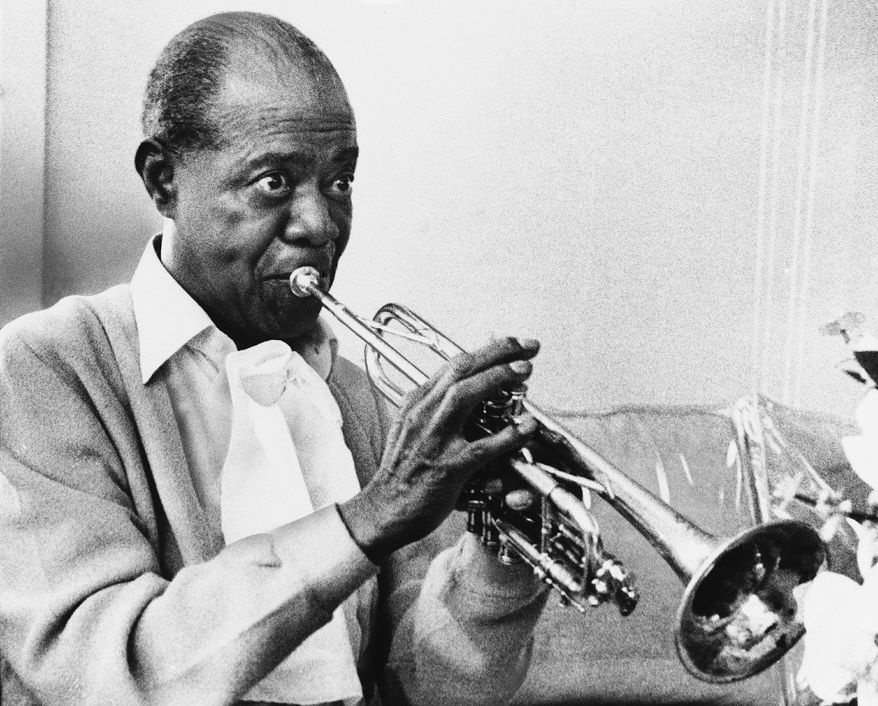 Louis Armstrong died July 6, 1971, just days after this photo of the trumpet master practicing at home in New York was taken. The jazz great broke racial barriers with his broad appeal. (Associated Press)