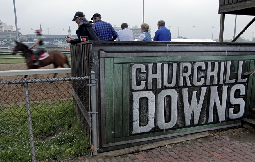 Spectators watch as horses workout at Churchill Downs on Tuesday, May 1, 2012, in Louisville, Ky. (AP Photo/Charlie Riedel)