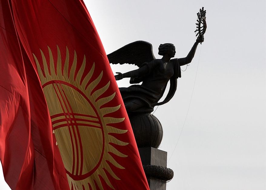 **FILE** The Kyrgyz national flag flies at half staff April 9, 2010, in front of the statue of independence on a central square in Bishkek, Kyrgyzstan. (Associated Press)