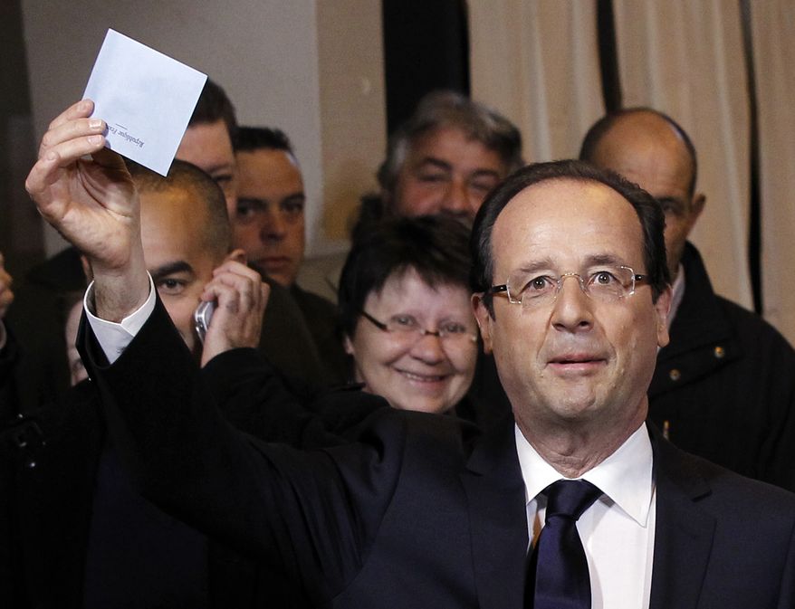 Socialist Party presidential candidate Francois Hollande shows his ballot before voting in the second round of the French presidential election in Tulle, France, on Sunday, May 6, 2012. (AP Photo/Christophe Ena)